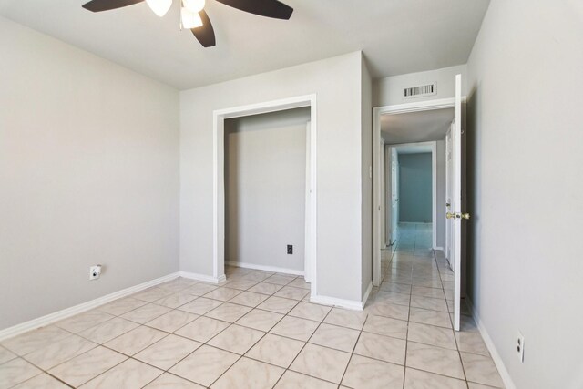 5001 N Colony Blvd, The Colony, TX 75056 - unfurnished bedroom with a ceiling fan, light tile patterned flooring, and baseboards