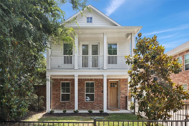 1028 Cavour Pl, Dallas, TX 75204 - view of front facade featuring covered porch, a balcony, brick siding, and a fenced front yard