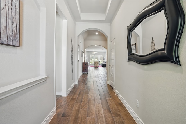 3904 Purple Sage Dr, Aubrey, TX 76227 - corridor with dark wood-type flooring, arched walkways, baseboards, and a tray ceiling