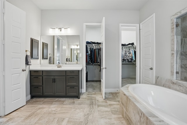 3904 Purple Sage Dr, Aubrey, TX 76227 - bathroom featuring vanity, a bath, a walk in closet, tiled shower, and baseboards