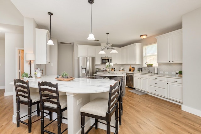 1304 Waterdown Dr, Allen, TX 75013 - kitchen featuring stainless steel appliances, a sink, light wood finished floors, and a breakfast bar