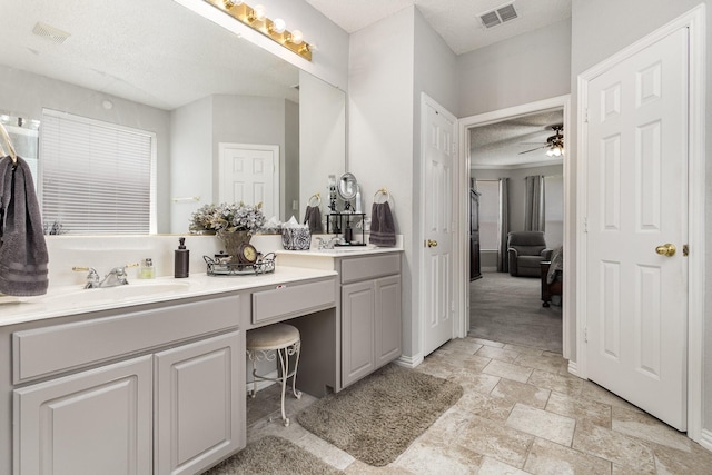 1304 Waterdown Dr, Allen, TX 75013 - full bath with double vanity, a textured ceiling, a ceiling fan, stone finish floors, and baseboards