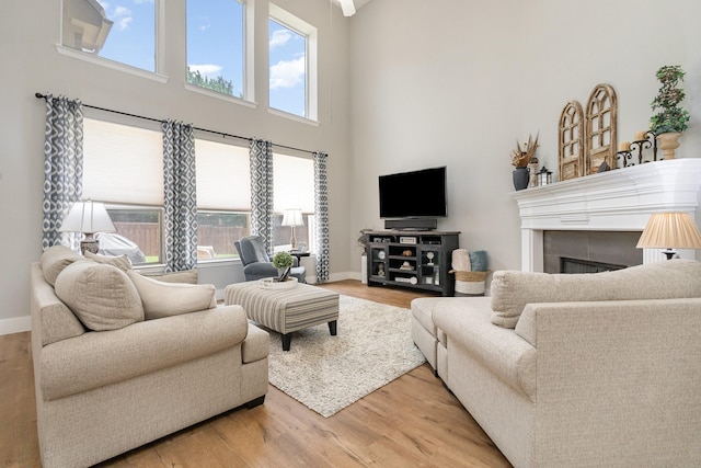 1304 Waterdown Dr, Allen, TX 75013 - living room featuring a towering ceiling, light wood-style floors, baseboards, and a fireplace
