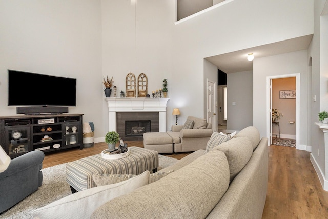 1304 Waterdown Dr, Allen, TX 75013 - living area featuring a tile fireplace, wood finished floors, baseboards, and a high ceiling