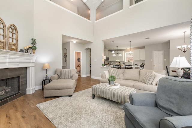 1304 Waterdown Dr, Allen, TX 75013 - living area with arched walkways, a towering ceiling, wood finished floors, baseboards, and a chandelier