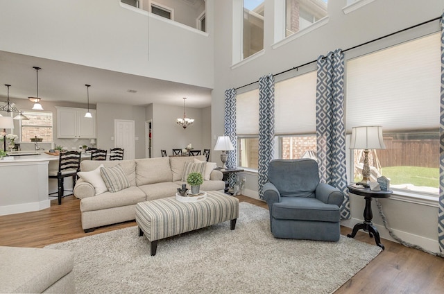 1304 Waterdown Dr, Allen, TX 75013 - living room with wood finished floors, a chandelier, baseboards, and a high ceiling