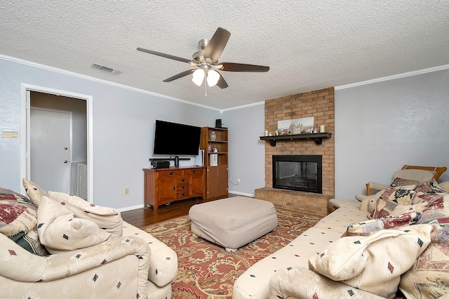 3929 Wrenwood Dr, Fort Worth, TX 76137 - living area featuring wood finished floors, a ceiling fan, ornamental molding, a textured ceiling, and a brick fireplace