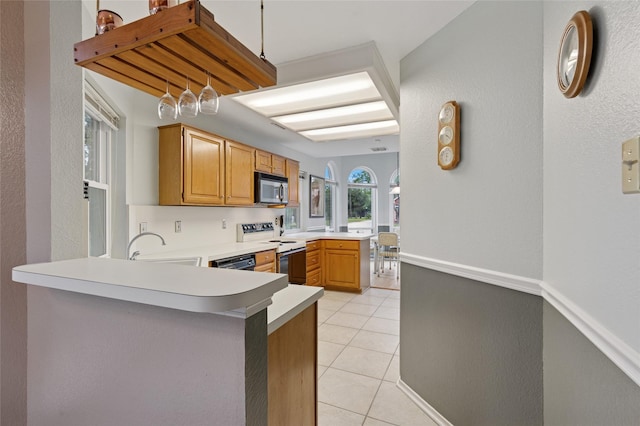 422 Arbor Creek Dr, Euless, TX 76039 - kitchen featuring white range with electric cooktop, stainless steel microwave, a peninsula, light tile patterned flooring, and light countertops