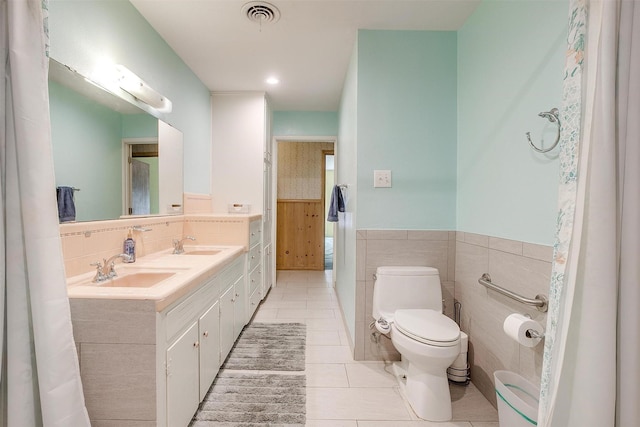 4524 Morris Ct, Fort Worth, TX 76103 - bathroom with double vanity, toilet, tile patterned floors, and wainscoting