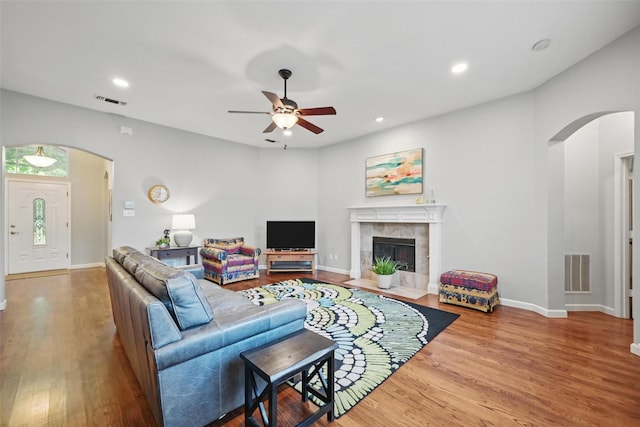 1325 Capstan Dr, Allen, TX 75013 - living area featuring arched walkways, ceiling fan, wood finished floors, baseboards, and a tile fireplace