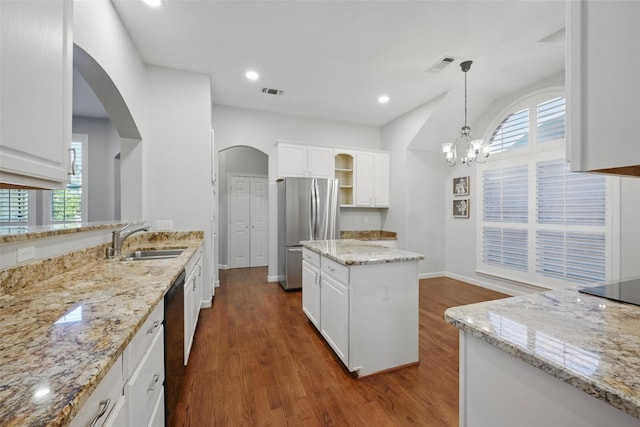 1325 Capstan Dr, Allen, TX 75013 - kitchen featuring a sink, freestanding refrigerator, dishwasher, arched walkways, and plenty of natural light