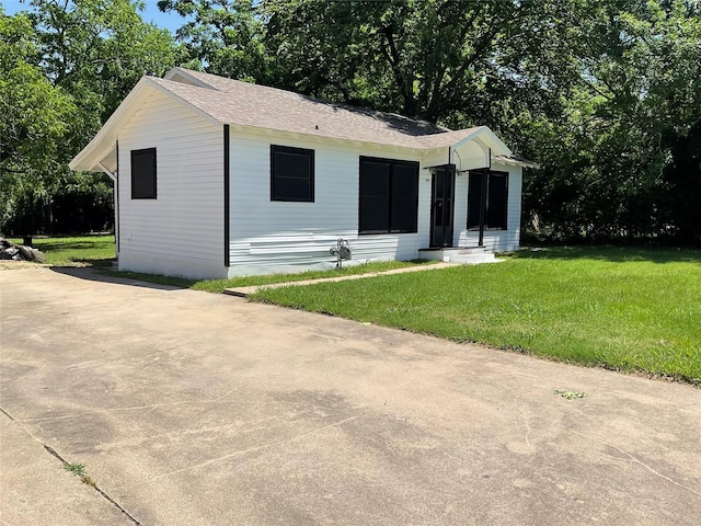 207 Bellview St, Sulphur Springs, TX 75482 - view of front facade with a front yard, roof with shingles, and view of wooded area