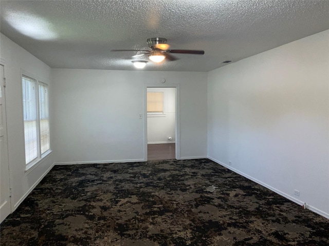 207 Bellview St, Sulphur Springs, TX 75482 - spare room with dark carpet, a textured ceiling, ceiling fan, and baseboards