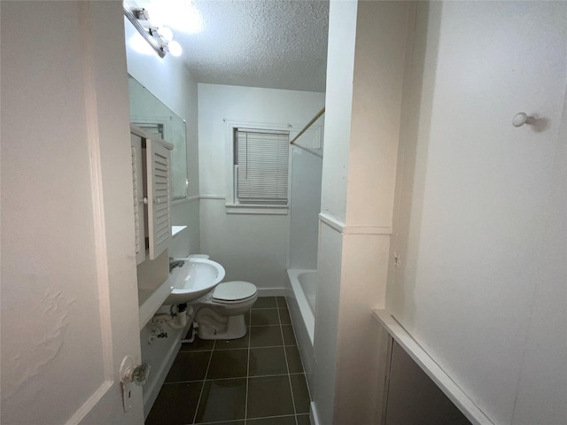 207 Bellview St, Sulphur Springs, TX 75482 - bathroom featuring toilet, tile patterned flooring, a textured ceiling, a sink, and  shower combination