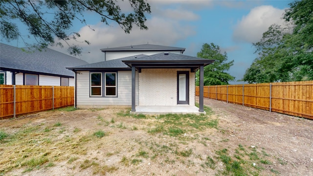 6860 Zuefeldt Dr, Arlington, TX 76002 - rear view of house with a patio, a fenced backyard, roof with shingles, and brick siding