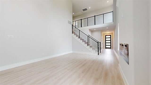 6860 Zuefeldt Dr, Arlington, TX 76002 - unfurnished living room with stairs, wood finished floors, baseboards, recessed lighting, and a high ceiling