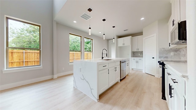 6860 Zuefeldt Dr, Arlington, TX 76002 - kitchen featuring a sink, appliances with stainless steel finishes, light wood-style flooring, decorative backsplash, and hanging light fixtures
