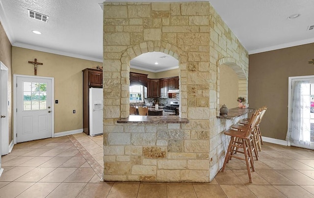 355 Texas 236 Hwy, Moody, TX 76557 - kitchen with white refrigerator with ice dispenser, gas stove, light tile patterned flooring, plenty of natural light, and ornamental molding