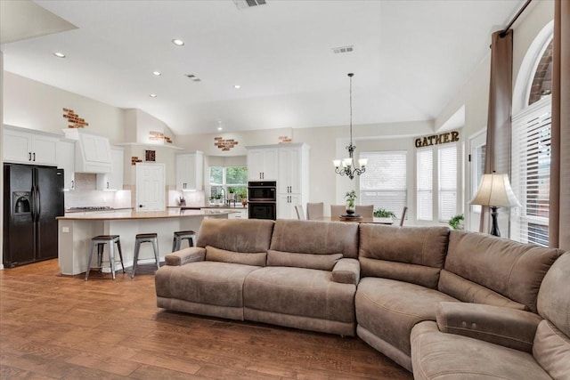 11538 Corsicana Dr, Frisco, TX 75035 - living area featuring lofted ceiling, a chandelier, wood finished floors, and recessed lighting