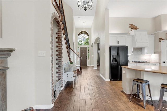 11538 Corsicana Dr, Frisco, TX 75035 - kitchen with black refrigerator with ice dispenser, a chandelier, white cabinets, and light wood finished floors