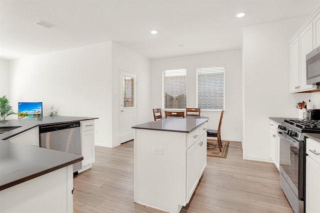 511 Poplar St, Princeton, TX 75407 - kitchen featuring appliances with stainless steel finishes, dark countertops, a center island, light wood-style flooring, and recessed lighting