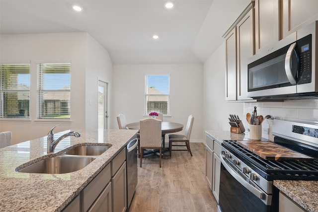 10425 Ponderosa Trl, Aubrey, TX 76227 - kitchen with appliances with stainless steel finishes, light wood finished floors, recessed lighting, light stone counters, and tasteful backsplash