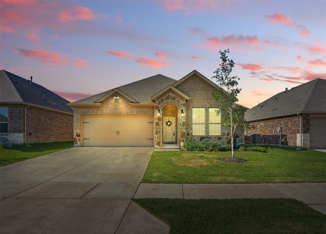 10425 Ponderosa Trl, Aubrey, TX 76227 - view of front of house with brick siding, an attached garage, concrete driveway, a front yard, and stone siding