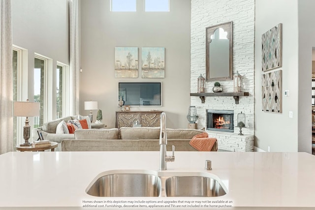 1107 Peacock Ln, Wylie, TX 75098 - kitchen with a towering ceiling, a sink, open floor plan, healthy amount of natural light, and a stone fireplace