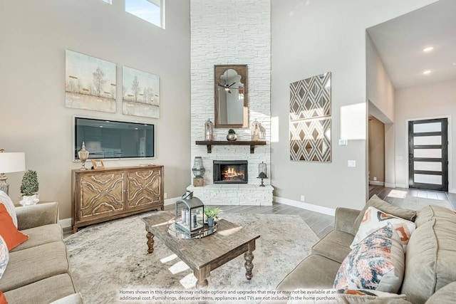 1107 Peacock Ln, Wylie, TX 75098 - living area with a high ceiling, a stone fireplace, baseboards, wood finished floors, and recessed lighting