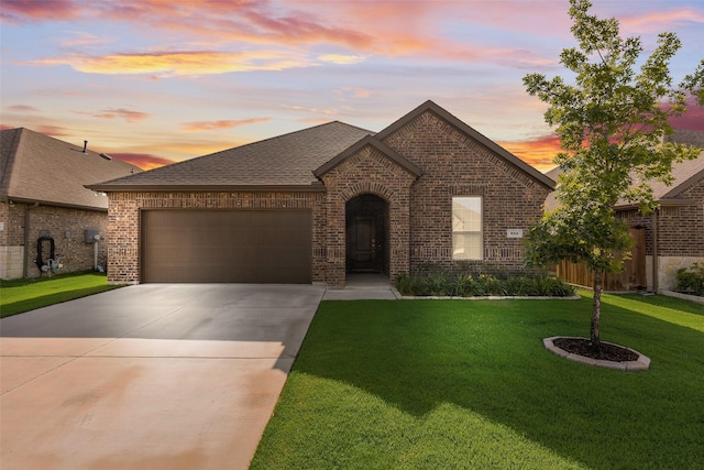 855 Revere Ct, Fate, TX 75189 - french country home with brick siding, concrete driveway, an attached garage, a front lawn, and a shingled roof