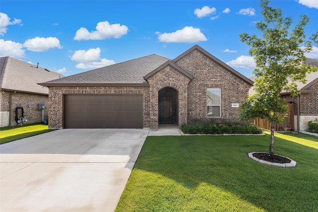 855 Revere Ct, Fate, TX 75189 - french country home with brick siding, an attached garage, driveway, a front yard, and roof with shingles