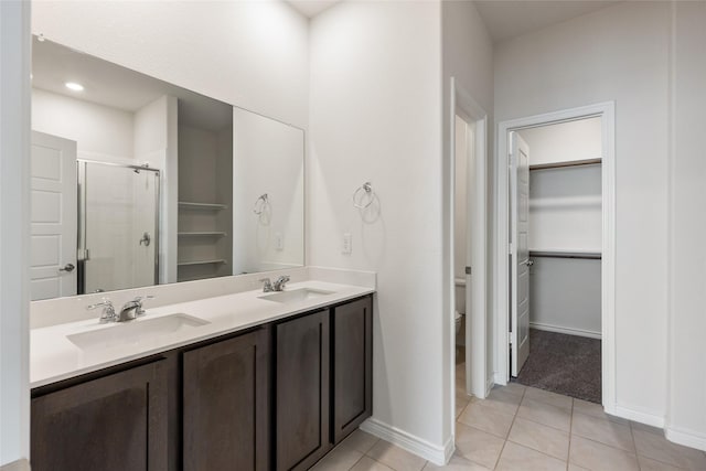 855 Revere Ct, Fate, TX 75189 - bathroom with a stall shower, toilet, double vanity, a spacious closet, and tile patterned floors