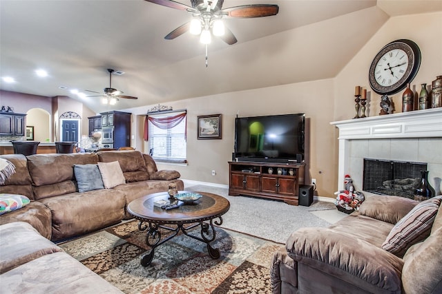 2318 Sparrow Dr, Forney, TX 75126 - carpeted living area with ceiling fan, vaulted ceiling, baseboards, a tiled fireplace, and arched walkways