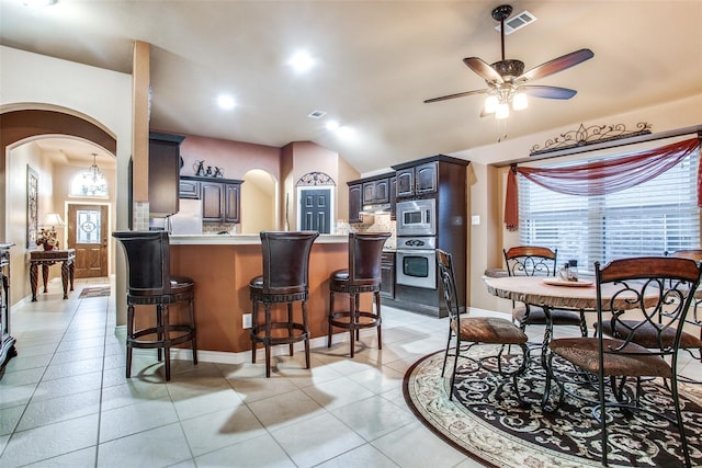 2318 Sparrow Dr, Forney, TX 75126 - dining space featuring arched walkways, a ceiling fan, light tile patterned floors, vaulted ceiling, and baseboards