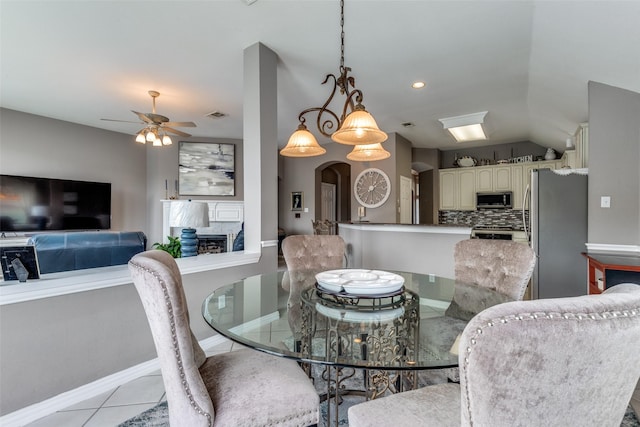 3832 Creekside Ln, Carrollton, TX 75010 - dining area featuring baseboards, vaulted ceiling, ceiling fan, light tile patterned floors, and arched walkways