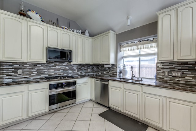 3832 Creekside Ln, Carrollton, TX 75010 - kitchen featuring appliances with stainless steel finishes, a sink, lofted ceiling, decorative backsplash, and light tile patterned floors