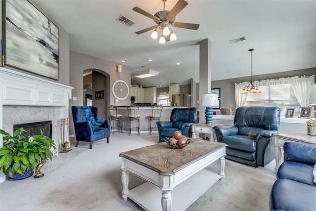 3832 Creekside Ln, Carrollton, TX 75010 - living area with lofted ceiling, light carpet, a ceiling fan, arched walkways, and a high end fireplace