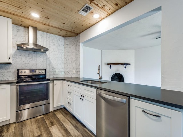 4857 Fallon Pl, Dallas, TX 75227 - kitchen with appliances with stainless steel finishes, wall chimney exhaust hood, a sink, dark countertops, and decorative backsplash