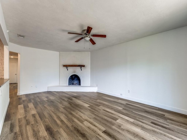 4857 Fallon Pl, Dallas, TX 75227 - unfurnished living room with a fireplace with raised hearth, a ceiling fan, dark wood-style floors, and baseboards