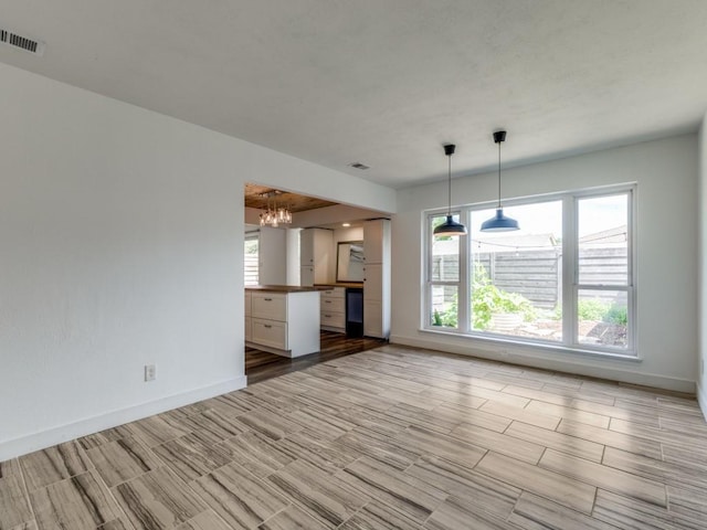 4857 Fallon Pl, Dallas, TX 75227 - unfurnished living room featuring baseboards, a chandelier, and wood tiled floors