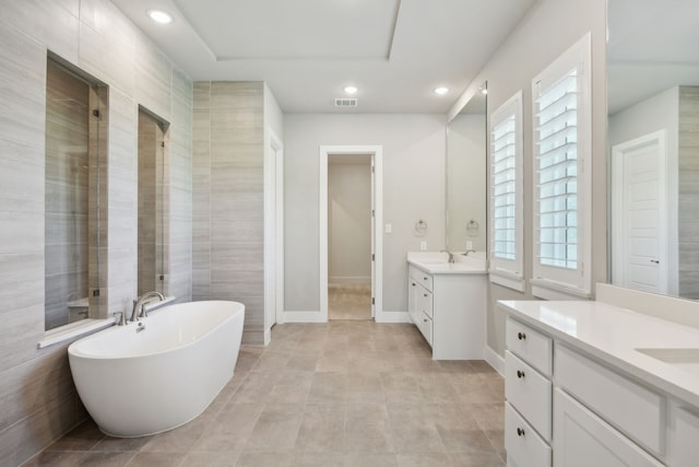 4106 Tamarack Ln, Royse City, TX 75189 - full bathroom with two vanities, a freestanding tub, recessed lighting, and baseboards