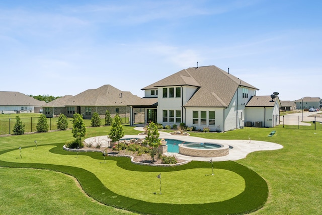 4106 Tamarack Ln, Royse City, TX 75189 - rear view of house with a putting area, a patio, a shingled roof, and a pool with connected hot tub