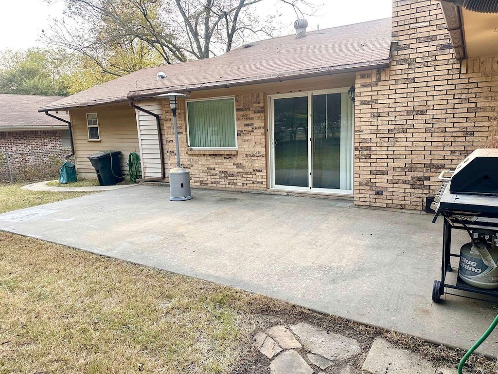 802 Pecan St, Bonham, TX 75418 - back of property with a patio, brick siding, and a chimney