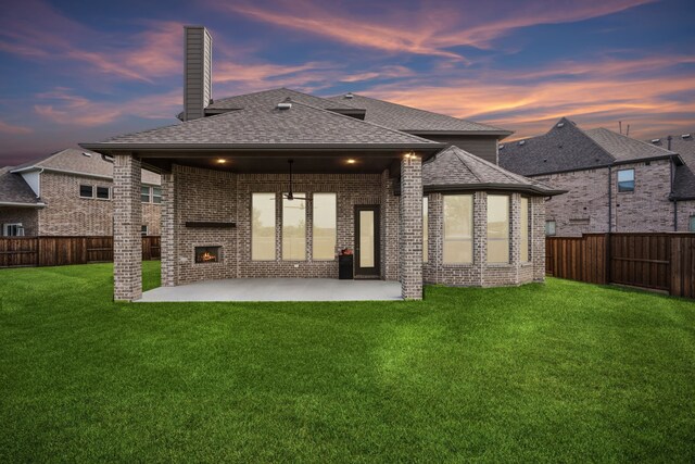 5901 Kildare Ct, Mckinney, TX 75071 - back of property at dusk featuring a fireplace, brick siding, a patio, a shingled roof, and a chimney
