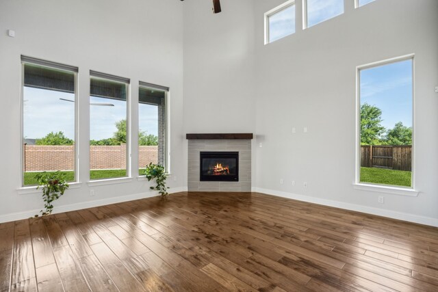 5901 Kildare Ct, Mckinney, TX 75071 - unfurnished living room with a high ceiling, ceiling fan, hardwood / wood-style floors, baseboards, and a tile fireplace