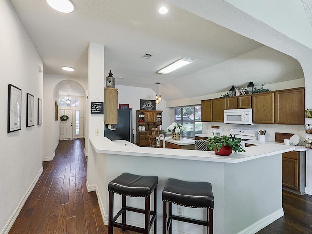 6023 Vista Ln, Sachse, TX 75048 - kitchen with white appliances, arched walkways, vaulted ceiling, light countertops, and recessed lighting