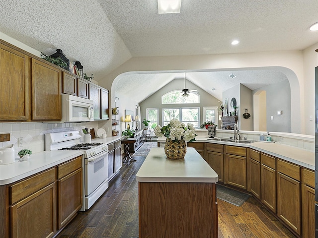 6023 Vista Ln, Sachse, TX 75048 - kitchen with white appliances, a sink, arched walkways, lofted ceiling, and light countertops