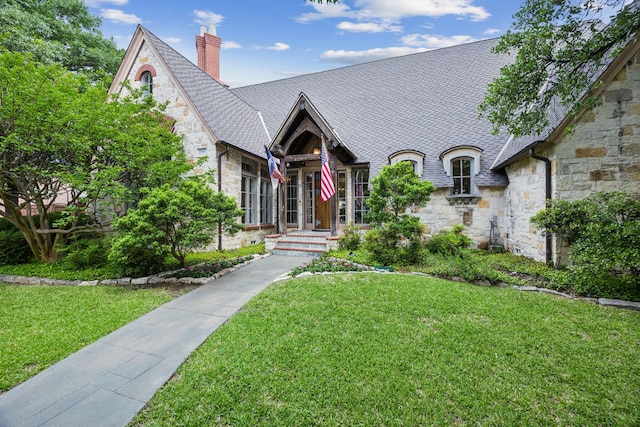6707 Meadow Rd, Dallas, TX 75230 - view of front of house with stone siding, a front yard, and a chimney