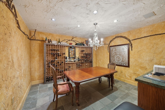 6707 Meadow Rd, Dallas, TX 75230 - wine area with a chandelier, a textured wall, and baseboards