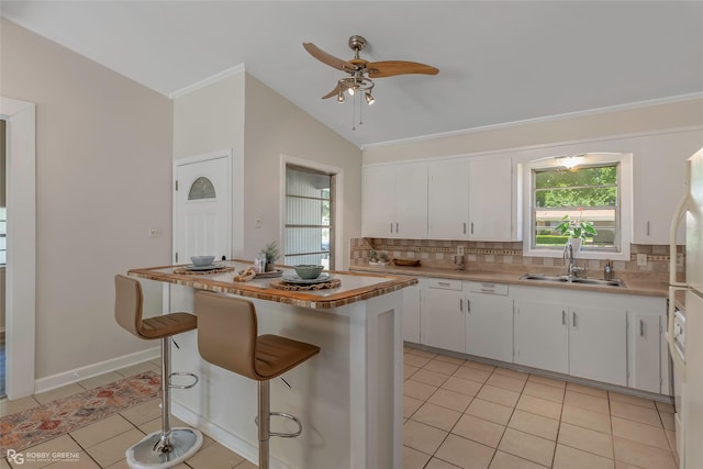 4102 Glen St, Bossier City, LA 71112 - kitchen with a sink, backsplash, plenty of natural light, white cabinetry, and lofted ceiling